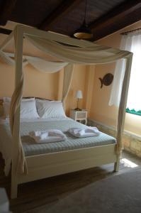 een slaapkamer met een hemelbed en handdoeken bij La Villa "Casa di Lydia" in Gavalochori