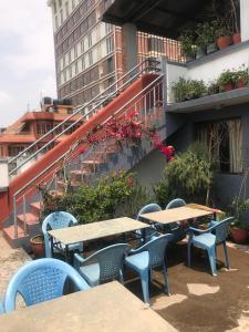 - un ensemble de tables et de chaises sur une terrasse dans l'établissement Hotel Earth House, à Katmandou