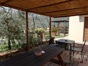菲耶索莱Agriturismo IL VIAIO的露台上的木桌和椅子