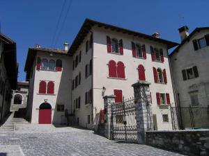 un grande edificio bianco con finestre rosse e un cancello di Panfilo Castaldi, romantica Feltre a Feltre