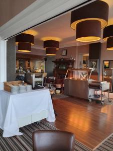ein Restaurant mit einem weißen Tisch, Stühlen und Lampen in der Unterkunft The York Hotel in Weston-super-Mare