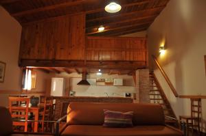 a living room with a couch and a kitchen at Casa Rural Casa de las Aves in Orellana la Vieja