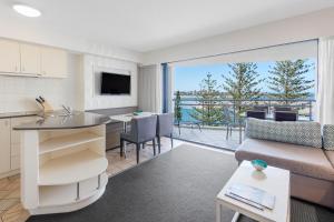 a kitchen and living room with a view of the ocean at Ramada Resort by Wyndham Golden Beach in Caloundra