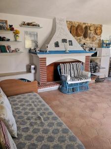 Villa Walter في أوليينا: غرفة بها موقد مع كرسيين وسرير