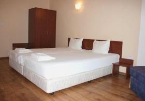 a bedroom with a large bed with white sheets at ХОТЕЛ РАДНЕВО in Radnevo +11 photos