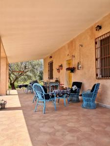 a patio with blue chairs and a table at Villa Walter in Oliena