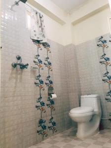 a bathroom with a toilet and a shower curtain with birds on it at Mangal homestay in Pokhara