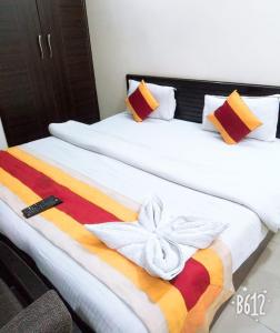 Hotel Marigold في نيودلهي: غرفة نوم مع سريرين مع بطانية ملونة