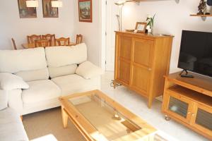 a living room with a white couch and a coffee table at Playazul seafront apartament in Cambrils