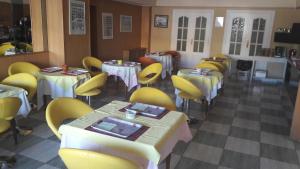 un comedor con mesas y sillas amarillas en Hotel Corona de Castilla, en Villares de la Reina