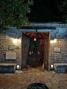 een toegang tot een bakstenen gebouw met een houten deur bij Princess Lanassa in Kostitsi