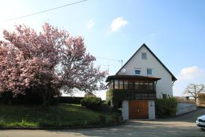 una casa bianca con un cancello e un albero di Ferienhaus an der Iller a Aitrach