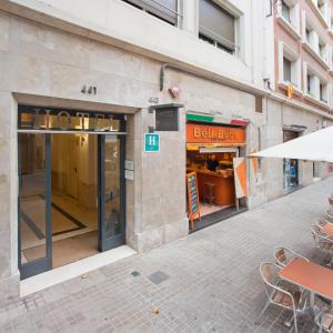 Hotel Everest في برشلونة: شارع فاضي فيه محل فيه طاولات وكراسي