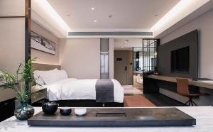 a bedroom with a bed and a desk and a tv at Harbin Week Inn Hotel in Harbin