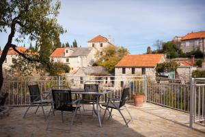 Un patio con mesa y sillas y una valla. en Villa Masha Brač, en Bobovišća