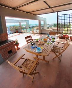 eine Terrasse mit einem Tisch, Stühlen und einem Kamin in der Unterkunft La Terrazza in Empoli