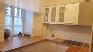 uma cozinha com armários brancos e um lavatório em Apartament Chlebnicka em Gdańsk