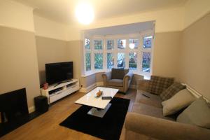 a living room with a couch and a tv at Oak Tree in London