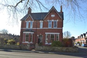uma casa de tijolos vermelhos ao lado de uma rua em Chilton House em Oswestry