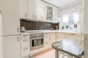 a kitchen with white cabinets and a table in it at Private House in Hannover +16 photos