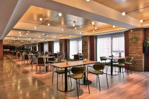 a restaurant with tables and chairs in a room at Harbin Week Inn Hotel in Harbin
