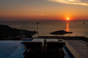 una piscina con tramonto sull'oceano di Jessica Luxury Villa a Agios Nikolaos