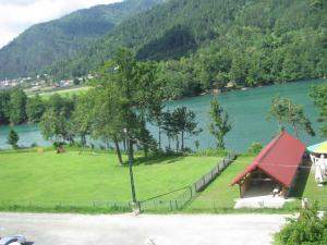 a green field with a house and a lake at Bungalow Perun in Blejska Dobrava