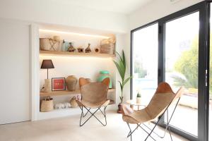 a living room with two chairs and a table at Aparthotel Niu d´Aus in Portopetro