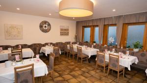 uma sala de jantar com mesas e cadeiras brancas em Hotel Lamm em Waiblingen