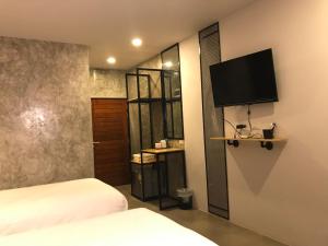a bedroom with a bed and a flat screen tv on the wall at Pimchanok Resort in Phetchaburi