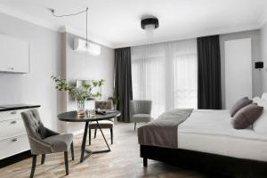 a bedroom with a bed and a table and chairs at My Regina in Gdańsk