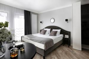 a bedroom with a large bed and a table at My Regina in Gdańsk