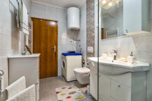 a bathroom with a sink and a toilet and a mirror at Apartments Kira, Mali Lošinj in Mali Lošinj +18 photos