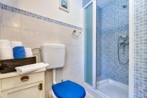a blue tiled bathroom with a toilet and a shower at Apartments Nautica, Mali Lošinj in Mali Lošinj