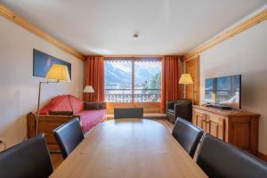 a living room with a wooden table and a couch at Les Balcons du Savoy in Chamonix-Mont-Blanc