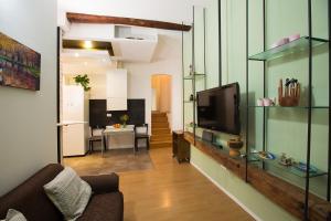 sala de estar con TV en una estantería de cristal en Guasto Apartment, en Bolonia