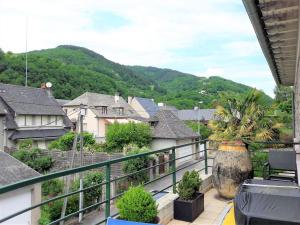 a balcony with a view of a town with mountains at Le Gîte de Jean in Entraygues-sur-Truyère
