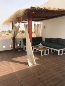 a living room with a couch and a table at Villa avec piscine in Triffa