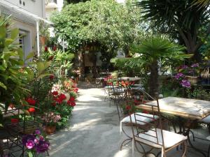 a patio area with tables, chairs and umbrellas at Logis Hôtel Villa Victorine in Nice