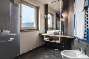 un bagno con due lavandini, un water e una finestra di Luis & die Buabm - Gasthof Jenesien a San Genesio Atesino
