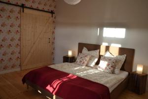 una camera da letto con un letto con due lampade e una porta di Ferienwohnung Heidjerleev a Eldingen