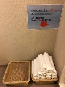 a sign above a basket of towels in a bathroom at Tokyo Guest House Itabashi-juku in Tokyo