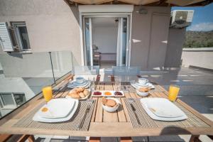 a wooden table with plates and bowls of food on it at Halcyon Panorama Villas in Agios Nikolaos