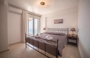 a bedroom with a bed and a large window at Halcyon Panorama Villas in Agios Nikolaos +37 photos