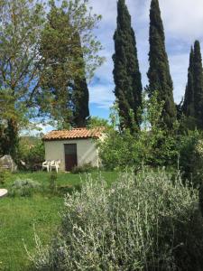 a small house in a garden with trees at la maison ocre in Saint-Julien-de-Briola