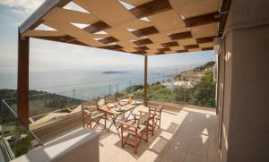 a patio with a table and chairs on a balcony at Halcyon Panorama Villas in Agios Nikolaos