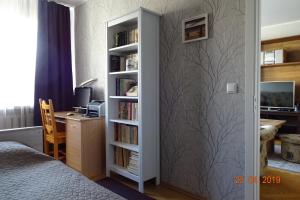 1 dormitorio con estantería de libros y escritorio en Prenzel Apartments - Mai, en Pärnu