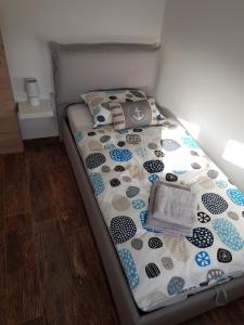 a bed with a comforter on it in a room at La Bella Vita Marezige in Marezige