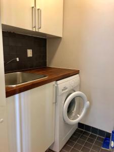 a small kitchen with a sink and a washing machine at Levin Rölli 2 in Levi +26 photos