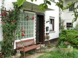 a bench in front of a house with roses at Lindenhof Hahn in Blankenrath